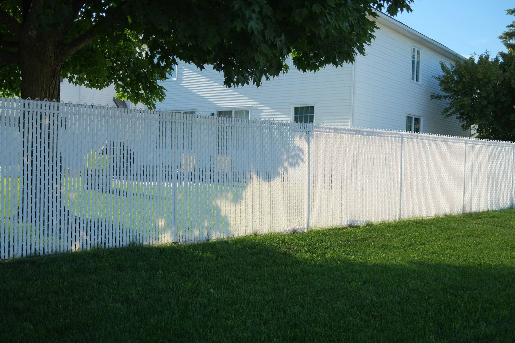 White vinyl privacy fence along a lawn