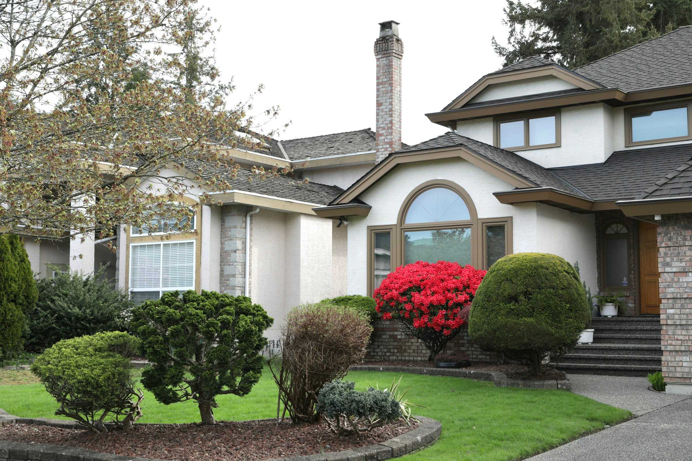 Front yard with trimmed shrubs, mulched beds and a green lawn